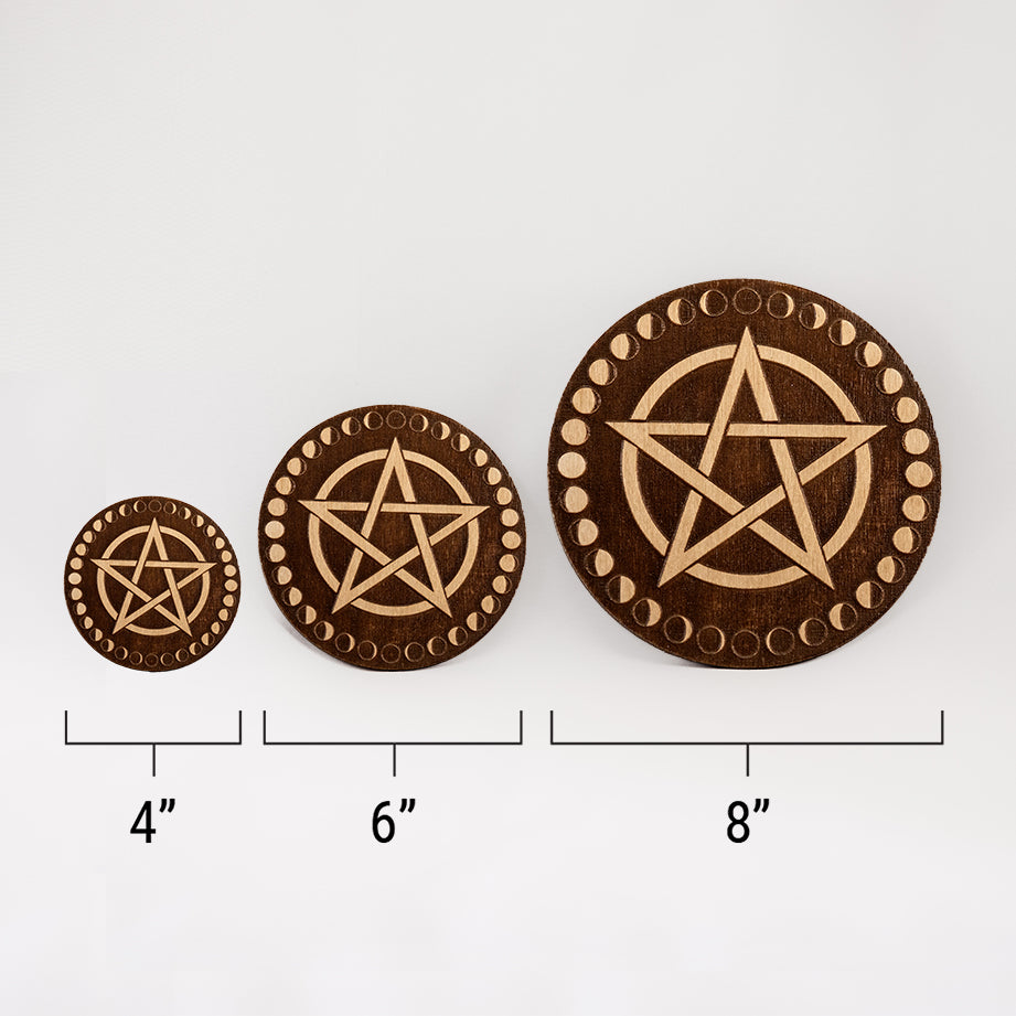 Three different sizes of the circular wooden laser-cut crystal grid engraved with a pentacle and a border made up of the cycles of the moon against a white background with a ruler underneath all three. The smallest measuring 4", the middle 6", and the largest 8".