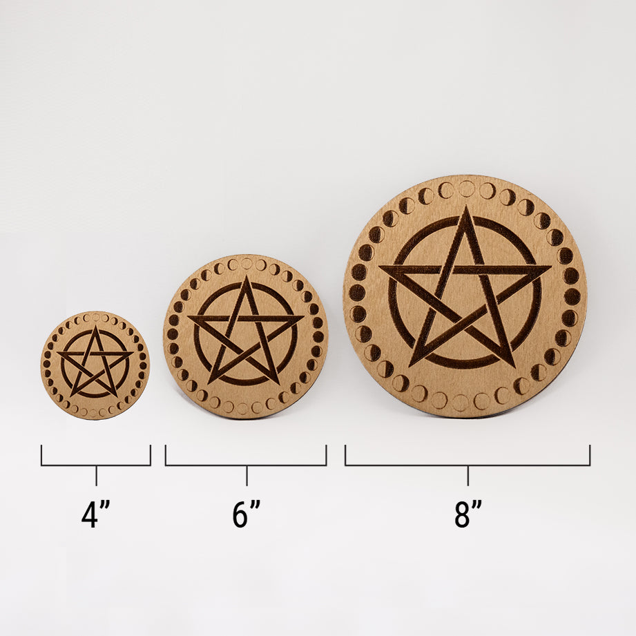 Three different sizes of the circular wooden laser-cut crystal grid engraved with a pentacle and a border made up of the cycles of the moon against a white background with a ruler underneath all three. The smallest measuring 4", the middle 6", and the largest 8".