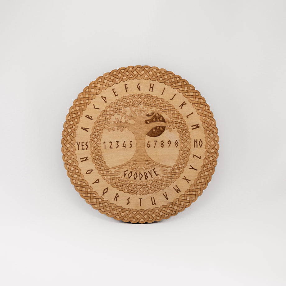 Circular Baltic birch laser-cut spirit board engraved with the words "yes", "no", "goodbye", as well as the entire alphabet. The board has the Tree of Life in the centre and a decorative die-cut braid border.