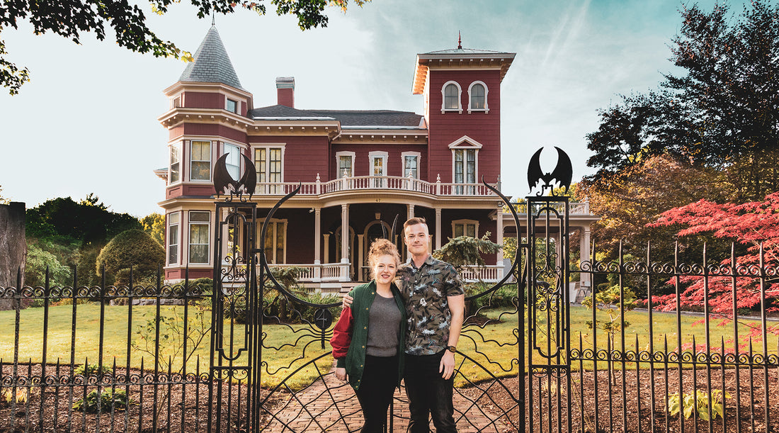 Blog creators Danielle and Kris stand in front of the wrought iron gate in front of writer Stephen King's home