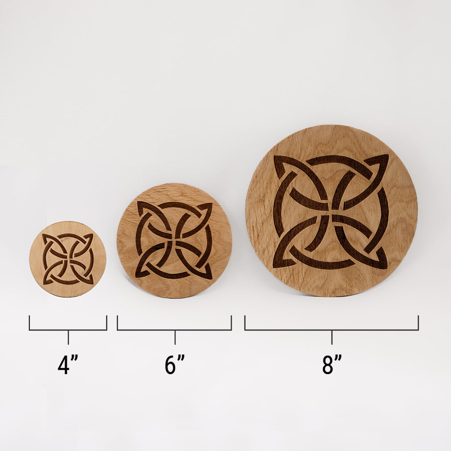 Three different sizes of the circular wooden laser-cut crystal grid engraved with a Celtic knot against a white background with a ruler underneath all three. The smallest measuring 4", the middle 6", and the largest 8".