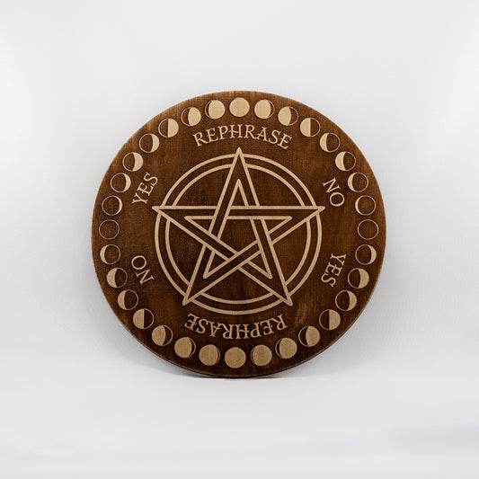 Circular Baltic birch laser-cut pendulum board engraved with the words "yes", "no", "rephrase",  a decorative moon phase border, and a large pentacle in the middle.