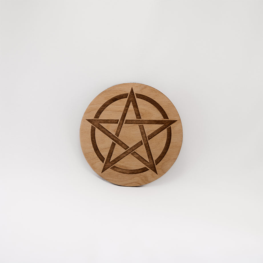 A circular wooden laser-cut crystal grid engraved with a Pentacle with a plain white background. 