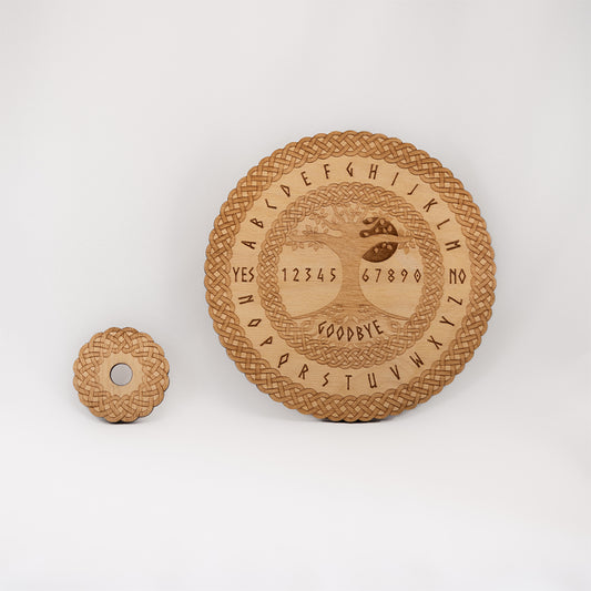 Circular Baltic birch laser-cut spirit  board engraved with the words "yes", "no", "goodbye", as well as the entire alphabet. The board has the Tree of Life in the centre and a decorative die-cut braid border. To the side of the spirit board there is a small circular planchette with a matching die-cut braid border. 