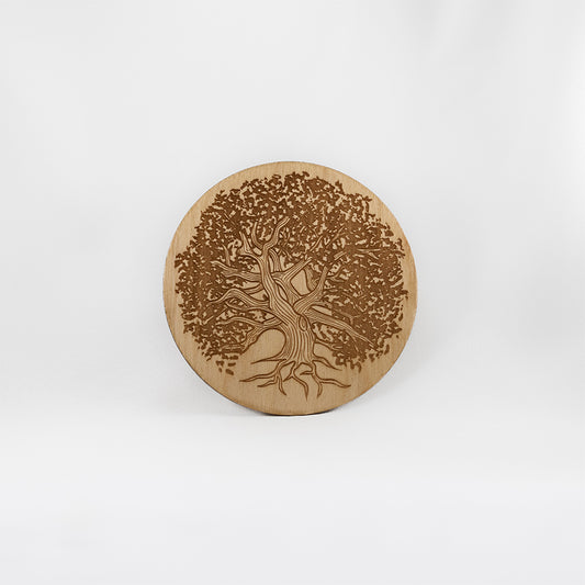 A circular wooden laser-cut crystal grid engraved with a gnarly old tree with a plain white background. 