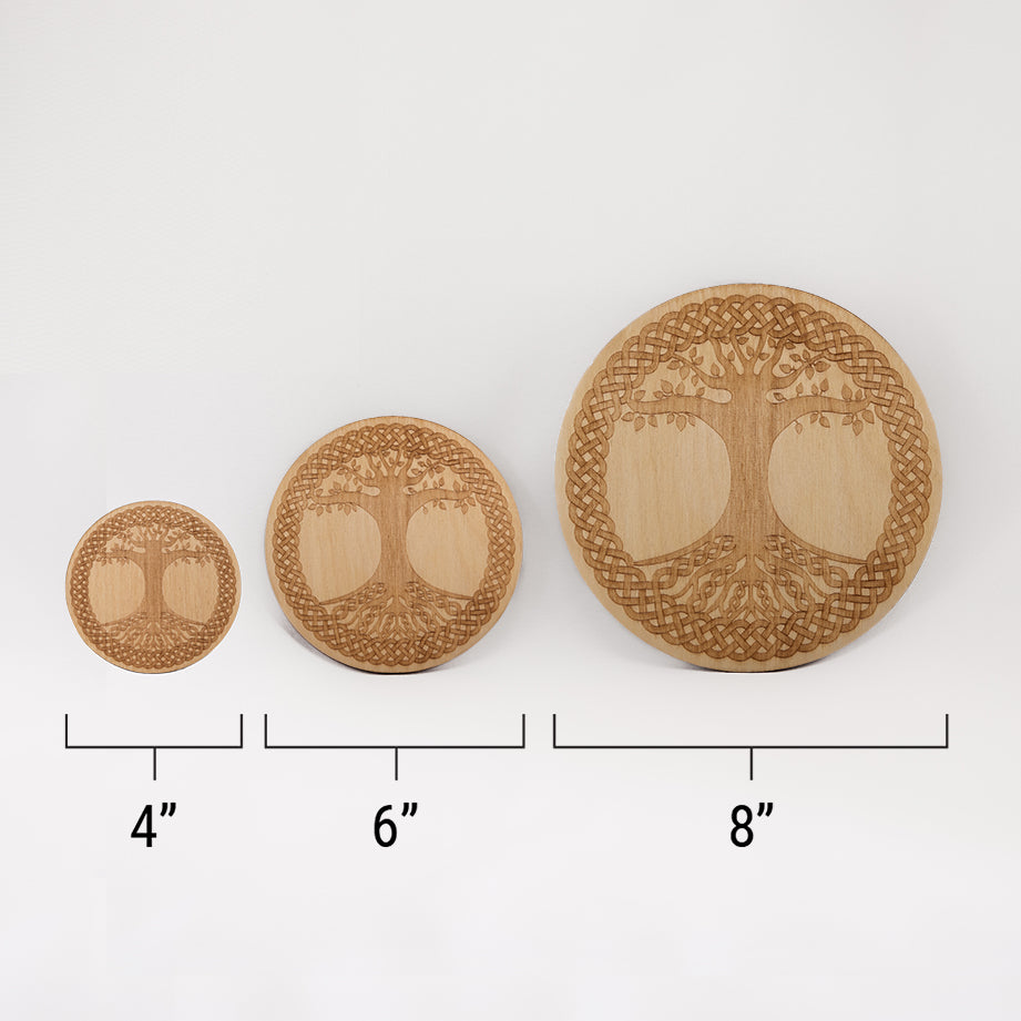 Three different sizes of the circular wooden laser-cut crystal grid engraved with the Celtic Tree of Life. against a white background with a ruler underneath all three. The smallest measuring 4", the middle 6", and the largest 8".